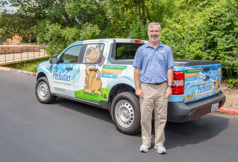 Coby Hough, Silver Springs Pet Butler owner, is standing next to a Pet Butler truck.