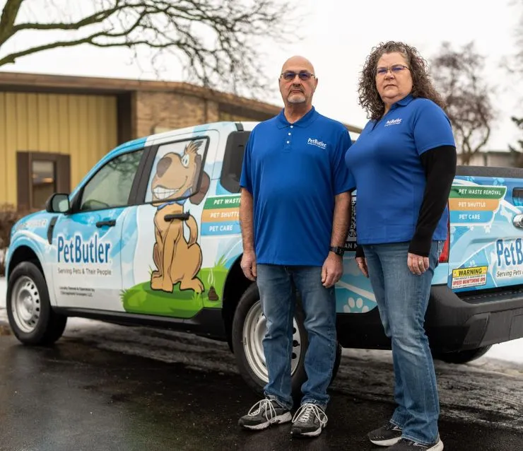 Michelle and Jeff Wilcox, owners of Pet Butler of Lansing, MI, standing next to a Pet Butler truck.