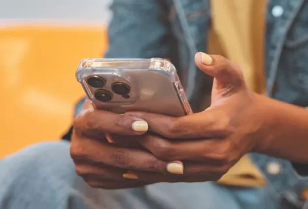 A mobile phone held in the palms of the user's hands.